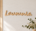 Drewniany napis Laurunia w przytulnym wnętrzu.png